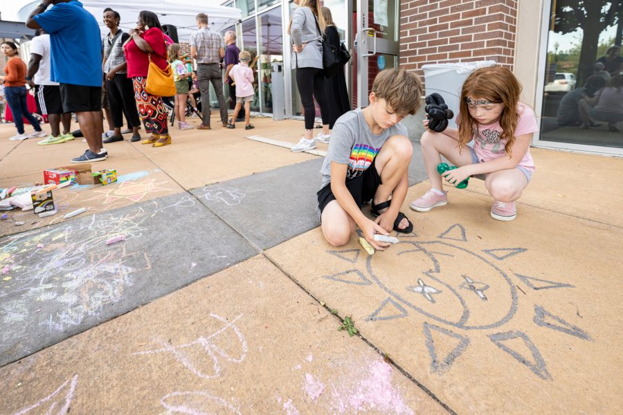 Young attendees leave their artistic mark on the sidewalk during a community celebration event held at the University of Wisconsin–Madison South Madison Partnership on South Park Street on Aug. 25, 2022.